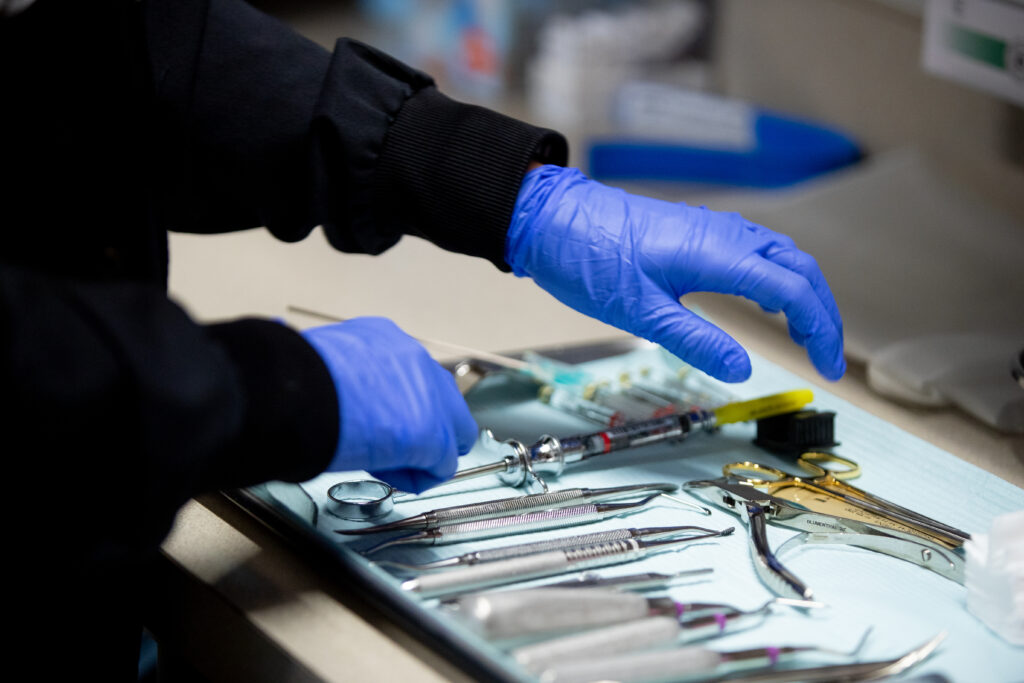 surgical assistant reaching for oral surgery tool