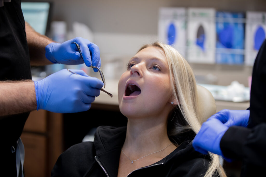 young woman with her mouth open during oral surgery consultation