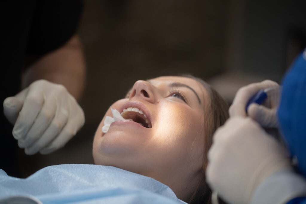 young woman with her mouth open at the oral surgeon's office