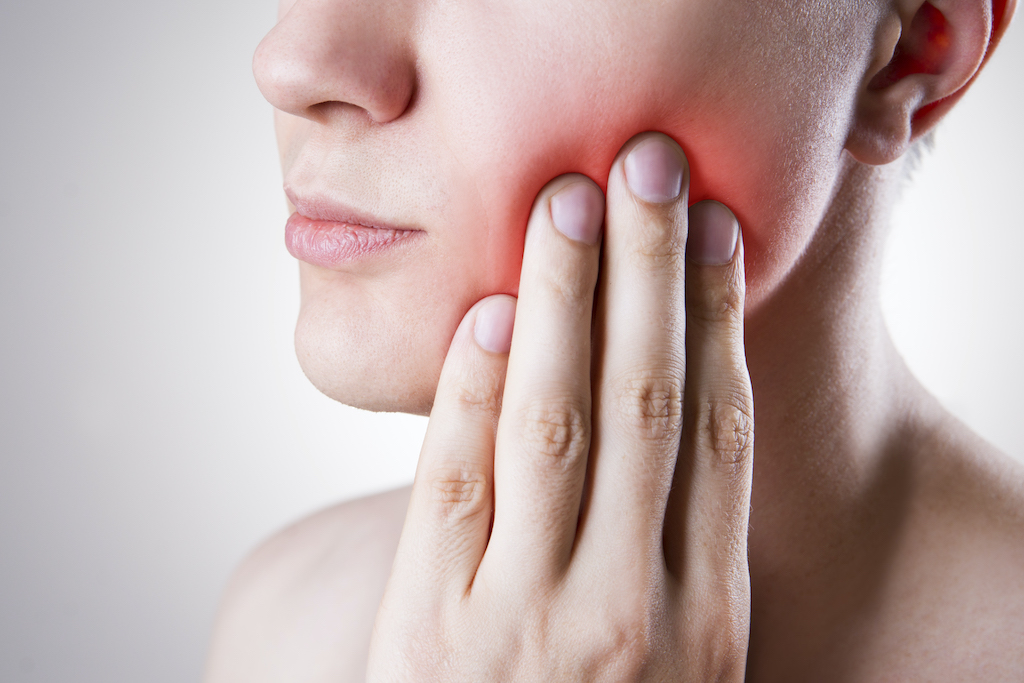 woman holding her painful jaw