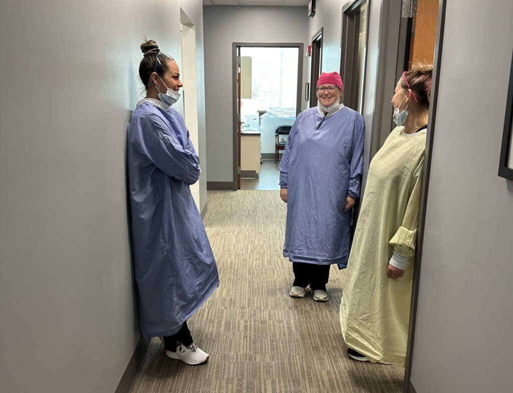 surgical team members standing in the hallway smiling and visiting