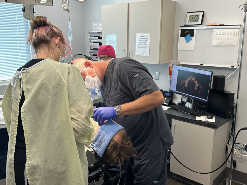 Oral surgeon and team working on a patient's mouth