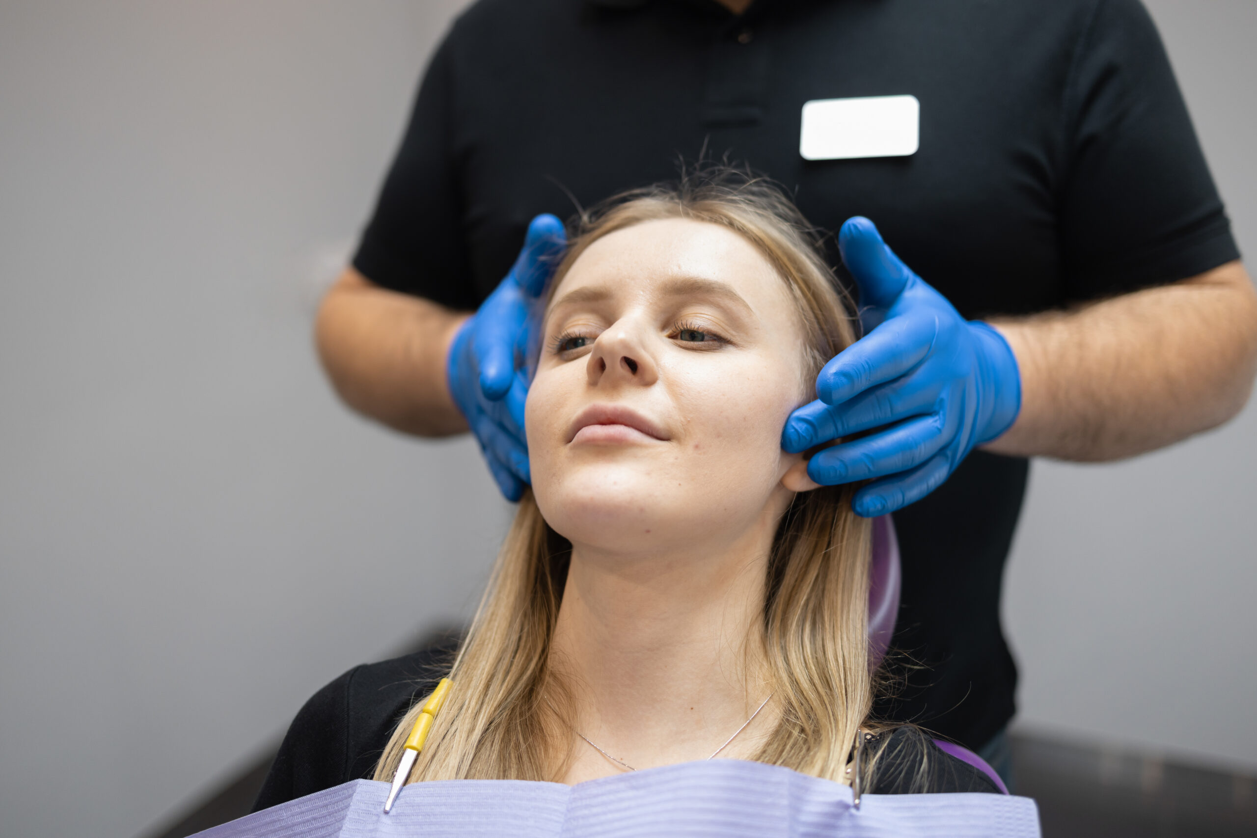 doctor palpitating a woman's jaw