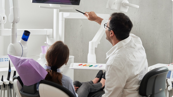 Doctor pointing at a screen and discussing a procedure with a patient