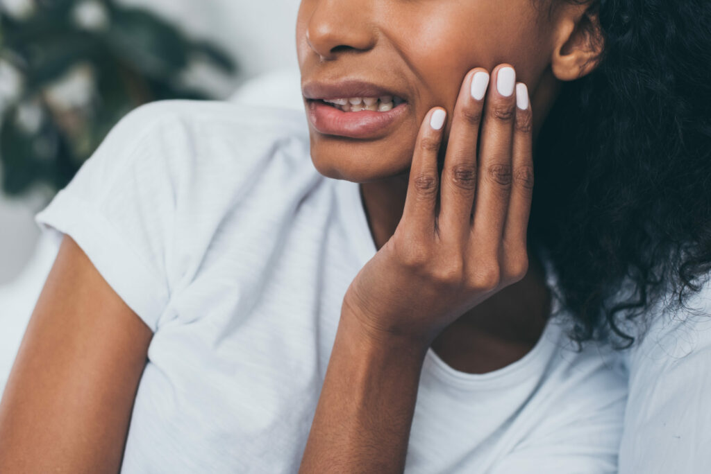 woman holding her jaw in pain